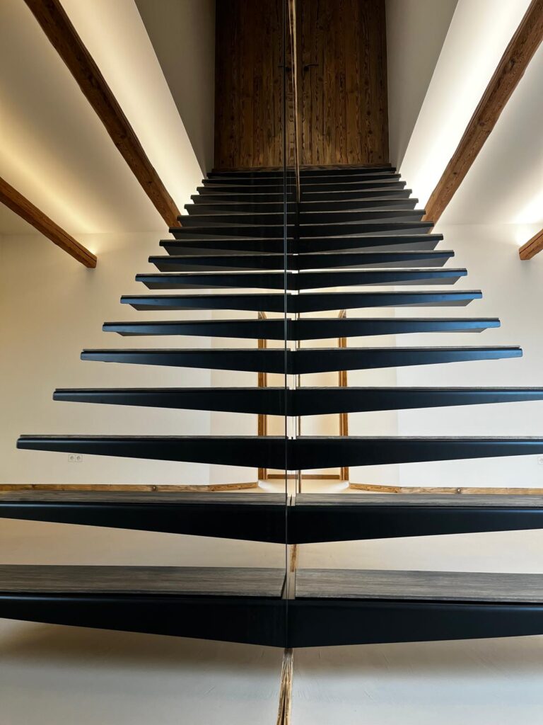 schwebend wirkende Kragarmtreppe durch Spiegelwand in Passau